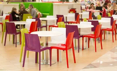 Интерьер общественной столовой с цветными пластиковыми стульями и столами |  Премиум Фото