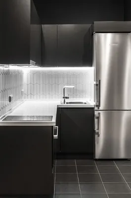 Идея для дизайна: серебряный холодильник на чёрной кухне